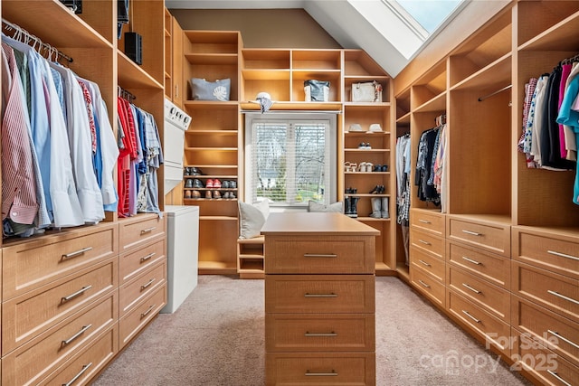 walk in closet featuring vaulted ceiling with skylight and light carpet