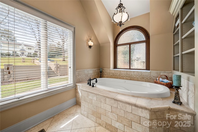 bathroom featuring baseboards, a garden tub, and tile patterned floors