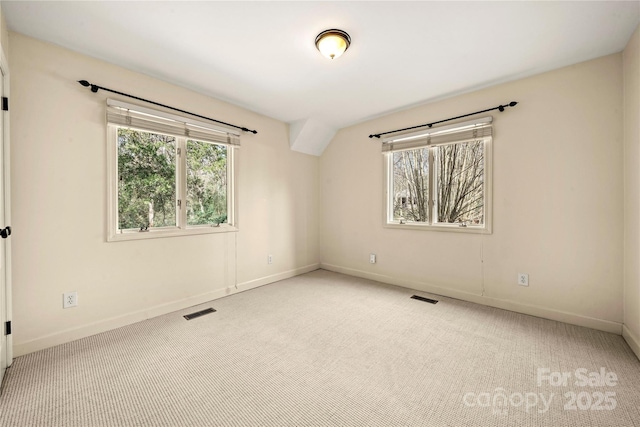 carpeted empty room with a wealth of natural light, visible vents, and baseboards