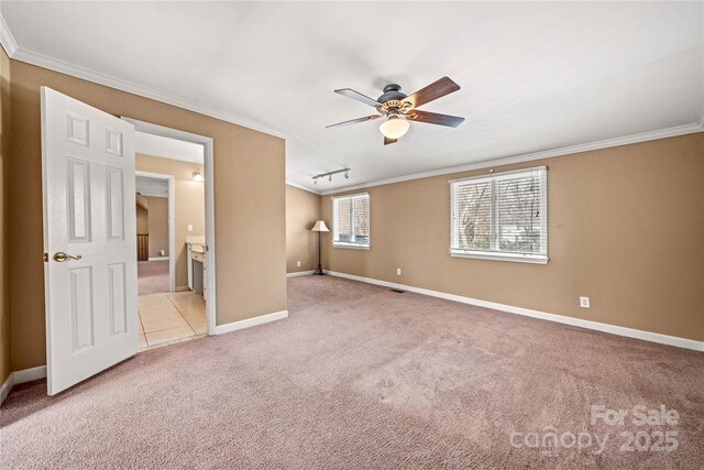 spare room featuring baseboards, a ceiling fan, crown molding, and light colored carpet