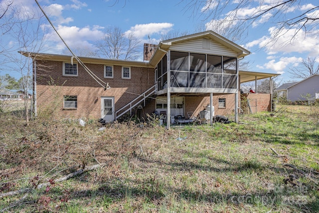 back of house with a sunroom and brick siding