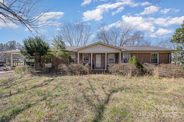 ranch-style home featuring brick siding and a porch