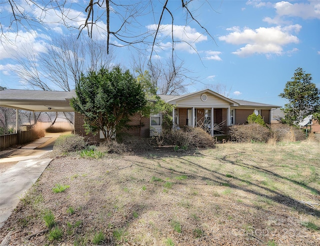 view of front of home with an attached carport, concrete driveway, and brick siding