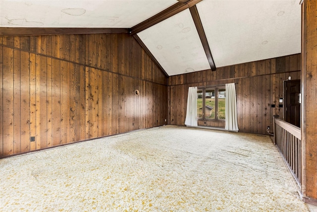 carpeted spare room featuring high vaulted ceiling, beam ceiling, and wood walls