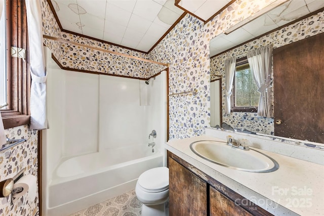 bathroom with wallpapered walls, toilet, bathtub / shower combination, crown molding, and vanity