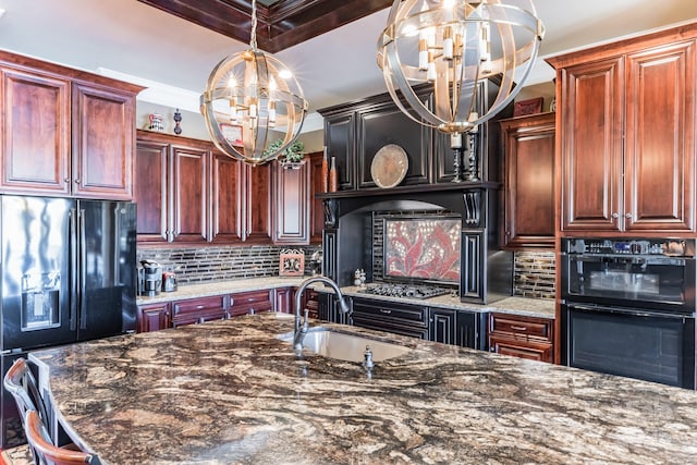 kitchen with a notable chandelier, tasteful backsplash, a sink, dark stone countertops, and black appliances