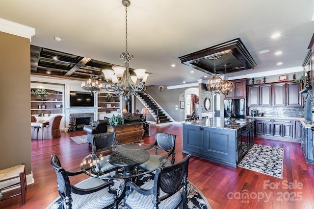 dining room featuring arched walkways, coffered ceiling, a fireplace, and dark wood finished floors