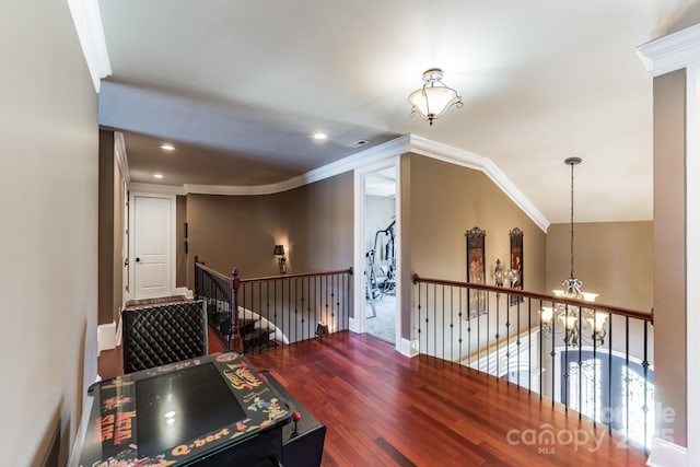 corridor featuring recessed lighting, a notable chandelier, wood finished floors, visible vents, and crown molding