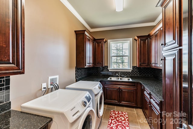 laundry area featuring ornamental molding, washing machine and dryer, light tile patterned flooring, and a sink