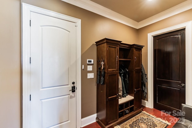 mudroom featuring dark wood-style flooring, crown molding, and baseboards