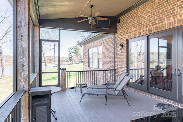 sunroom / solarium with a ceiling fan and lofted ceiling