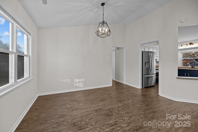 spare room with plenty of natural light, baseboards, and dark wood-style flooring