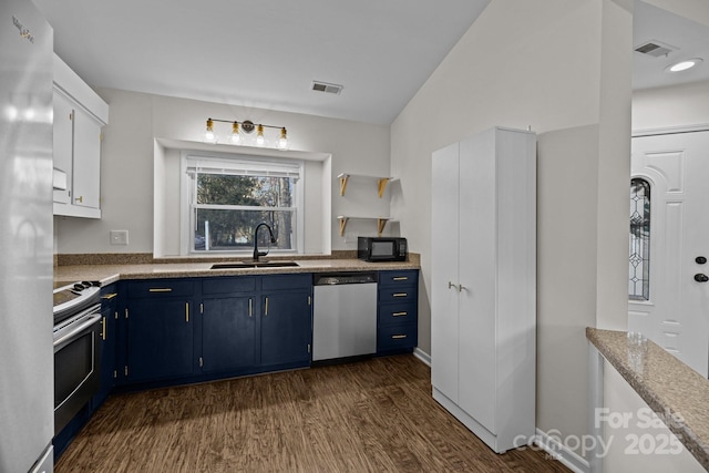 kitchen with blue cabinets, dark wood-style flooring, stainless steel appliances, and a sink