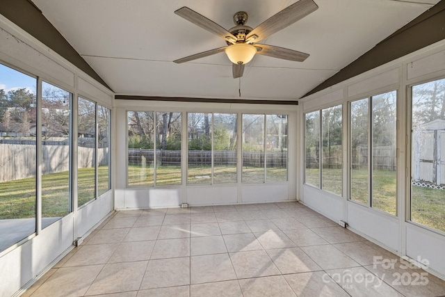 unfurnished sunroom with lofted ceiling, ceiling fan, and a wealth of natural light