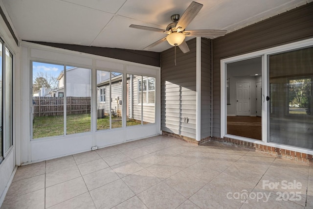 unfurnished sunroom with ceiling fan