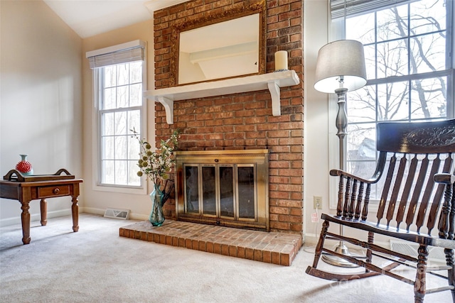 living room with carpet, a fireplace, visible vents, and a healthy amount of sunlight