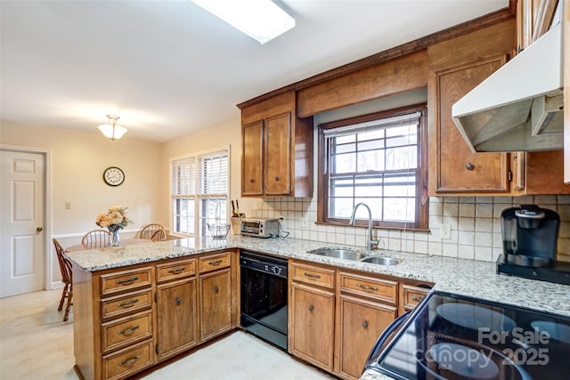 kitchen with black dishwasher, brown cabinets, a peninsula, under cabinet range hood, and a sink