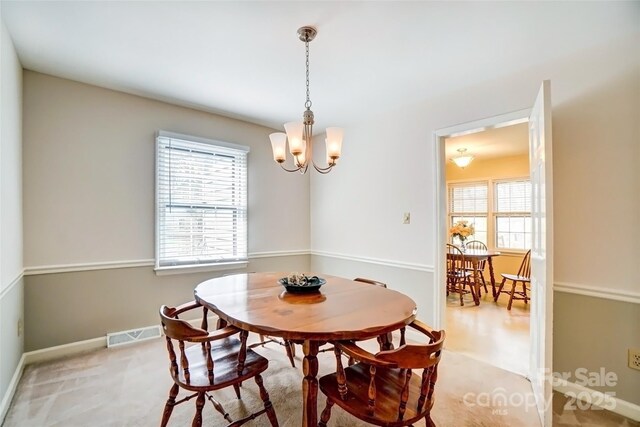 dining room with visible vents, baseboards, a wealth of natural light, and a notable chandelier