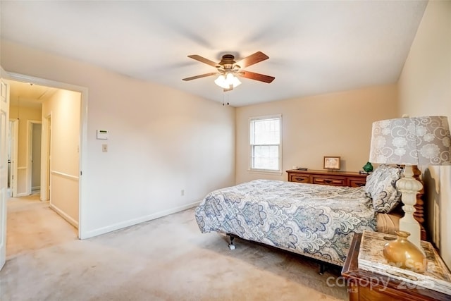 bedroom featuring attic access, light colored carpet, baseboards, and a ceiling fan