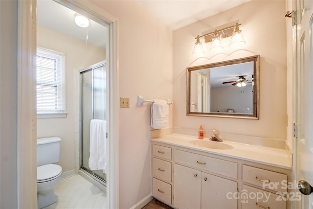 full bath with a stall shower, vanity, toilet, and baseboards