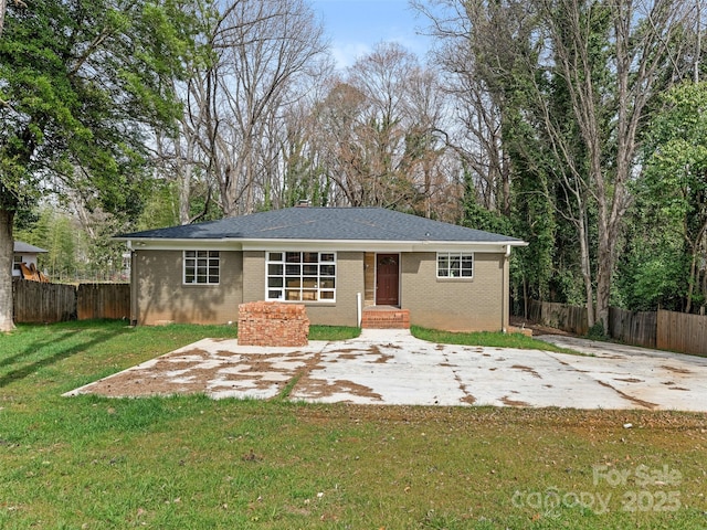 view of front facade with brick siding, fence, and a front yard