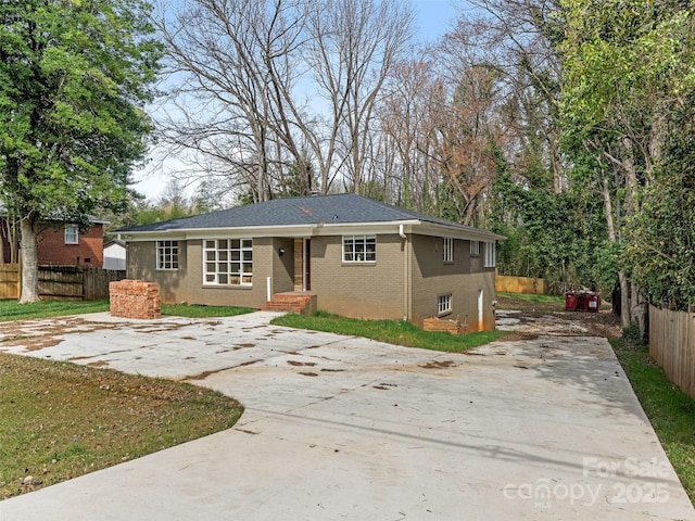 ranch-style home with brick siding, fence, and driveway