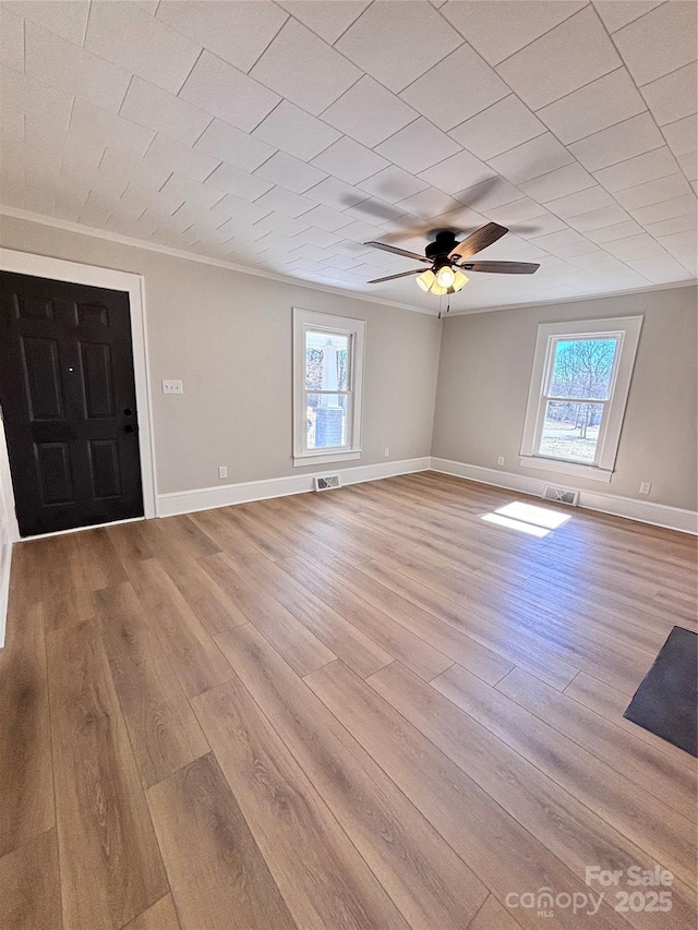 entryway featuring light wood-type flooring, crown molding, visible vents, and a wealth of natural light