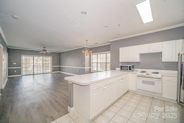 kitchen with ornamental molding, plenty of natural light, white electric range, and stainless steel microwave