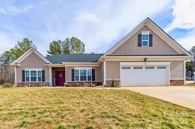 craftsman inspired home with board and batten siding, a front yard, stone siding, and driveway