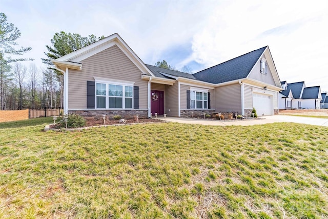 view of front of house featuring stone siding, a front lawn, concrete driveway, and fence