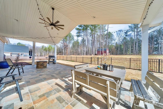 view of patio featuring ceiling fan, an outdoor fire pit, outdoor dining space, and a fenced backyard