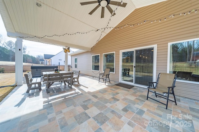 view of patio with outdoor dining space, a ceiling fan, and a hot tub