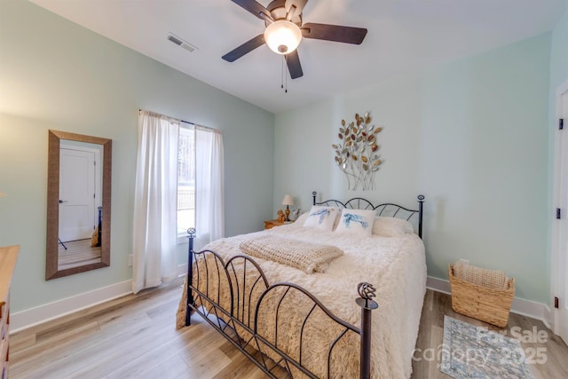 bedroom with light wood finished floors, baseboards, visible vents, and ceiling fan