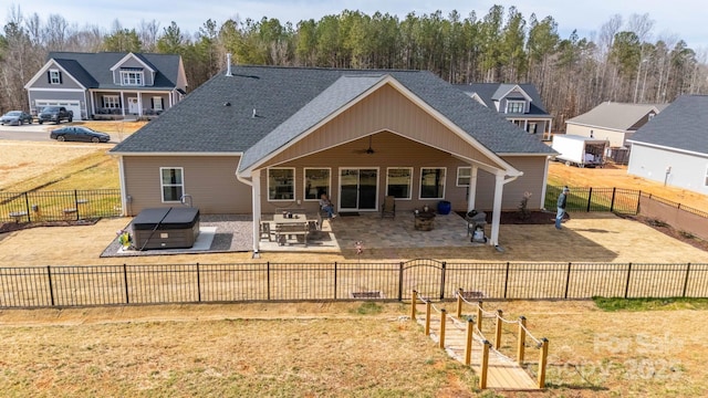 back of house featuring a hot tub, a patio area, a fenced backyard, and roof with shingles