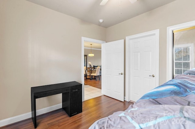 bedroom with ceiling fan, baseboards, and wood finished floors