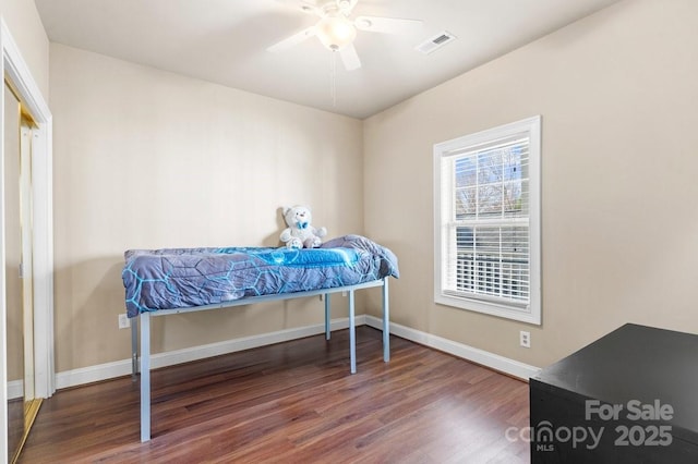 bedroom with a ceiling fan, wood finished floors, visible vents, and baseboards