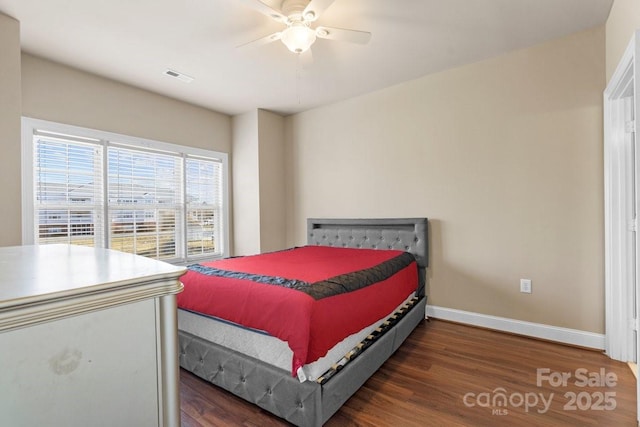 bedroom featuring a ceiling fan, visible vents, baseboards, and wood finished floors