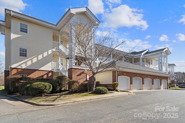 view of side of home with brick siding and a balcony