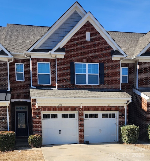 townhome / multi-family property with brick siding, concrete driveway, an attached garage, and a shingled roof