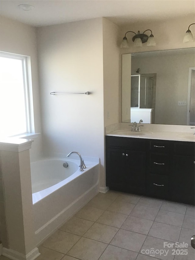 bathroom with tile patterned flooring, walk in shower, a garden tub, and double vanity