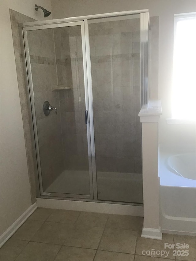 full bathroom with baseboards, a bath, a shower stall, and tile patterned flooring