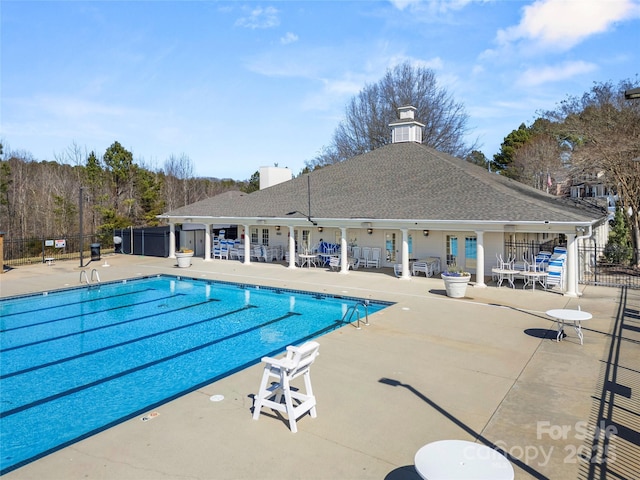 community pool featuring a patio area and fence