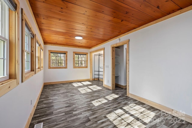 unfurnished room featuring wooden ceiling, visible vents, baseboards, and wood finished floors