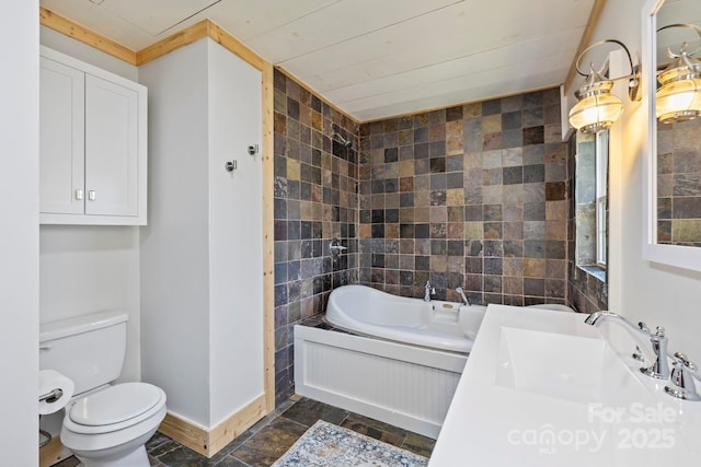 bathroom featuring baseboards, toilet, a sink, a bathtub, and tile walls