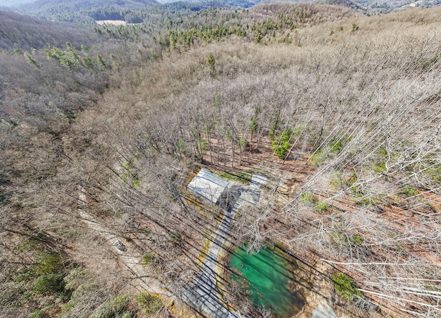 drone / aerial view featuring a water view and a wooded view