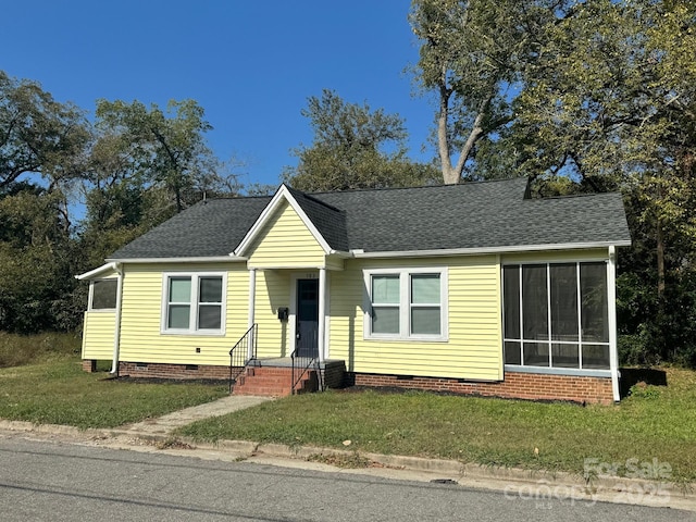 ranch-style house with a front yard, crawl space, and roof with shingles