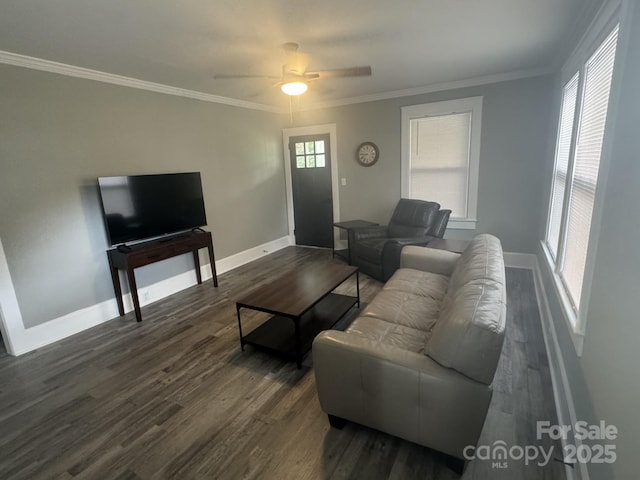 living area featuring ornamental molding, dark wood-style flooring, a ceiling fan, and baseboards