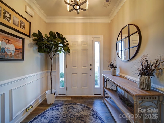 foyer entrance with wainscoting, visible vents, wood finished floors, and ornamental molding