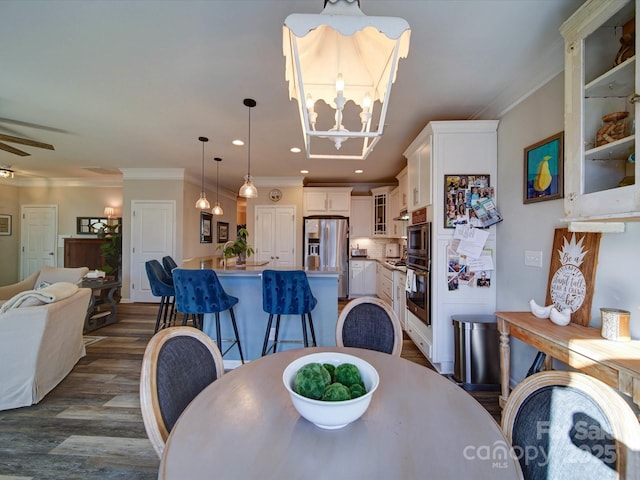 dining space featuring recessed lighting, ornamental molding, dark wood finished floors, and ceiling fan with notable chandelier