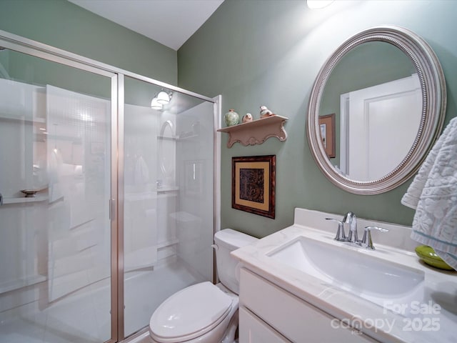 full bathroom with a stall shower, vanity, and toilet